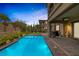 Refreshing backyard pool with stone trim, beautiful landscaping, and a charming patio, perfect for outdoor living at 11944 Dolcemente Ln, Las Vegas, NV 89138