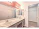 Bathroom featuring double sinks, a vanity, and a shower over the tub at 1425 Bow Creek Ct, Las Vegas, NV 89128