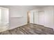 Bright bedroom featuring a gray wood floor, closet, and an entrance to the bathroom at 1425 Bow Creek Ct, Las Vegas, NV 89128