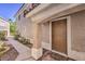 Home entrance featuring a brown front door, columned porch, and landscaped walkway at 1425 Bow Creek Ct, Las Vegas, NV 89128