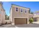 Tan home exterior featuring a two-car garage and neatly kept landscaping at 1425 Bow Creek Ct, Las Vegas, NV 89128