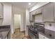 Kitchen with white cabinets, black appliances and black countertops leading to hallway at 1425 Bow Creek Ct, Las Vegas, NV 89128