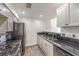 Kitchen with white cabinets, black appliances and black countertops with stainless sink at 1425 Bow Creek Ct, Las Vegas, NV 89128