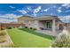 Spacious backyard with artificial turf, a covered patio, and a fully enclosed brick wall at 1634 Deep Valley Ave, North Las Vegas, NV 89084