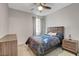 This bedroom features a ceiling fan, curtains, neutral walls, a bed, and nightstand at 1634 Deep Valley Ave, North Las Vegas, NV 89084