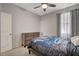 This bedroom features a ceiling fan, curtains, neutral walls, and a door to the room at 1634 Deep Valley Ave, North Las Vegas, NV 89084