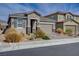 This house boasts a two-car garage, desert landscaping, and a neutral-colored exterior at 1634 Deep Valley Ave, North Las Vegas, NV 89084
