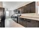 Stylish kitchen featuring dark cabinets, granite counters, stainless appliances, and tile floors at 1634 Deep Valley Ave, North Las Vegas, NV 89084