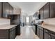 Modern kitchen with dark cabinets, granite countertops, stainless steel appliances, and tiled flooring at 1634 Deep Valley Ave, North Las Vegas, NV 89084