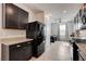Bright kitchen with a large refrigerator, granite countertops, dark cabinets, and tile flooring at 1634 Deep Valley Ave, North Las Vegas, NV 89084