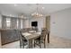 Open-concept living area with a dining table set, tile flooring, neutral walls, and modern lighting at 1634 Deep Valley Ave, North Las Vegas, NV 89084