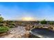 Landscaped backyard with stone pathways, rock features, mature trees and sunset views at 1637 Wellington Springs Ave, Henderson, NV 89052