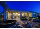 Inviting backyard patio with stone accents, a hot tub, and an outdoor seating area under a covered patio at 1637 Wellington Springs Ave, Henderson, NV 89052