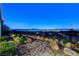 Beautiful backyard view with stone landscaping, greenery, and a picturesque city skyline in the distance at 1637 Wellington Springs Ave, Henderson, NV 89052