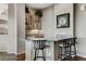 Bar area featuring upper cabinets with glassware display and granite countertop with seating for three at 1637 Wellington Springs Ave, Henderson, NV 89052