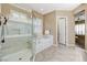 Bright bathroom featuring shower, soaking tub, tile flooring and a bright window at 1637 Wellington Springs Ave, Henderson, NV 89052