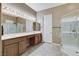Bright bathroom featuring a double sink vanity, framed mirror, and a glass-enclosed shower at 1637 Wellington Springs Ave, Henderson, NV 89052