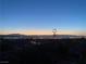 Distant city view at dusk with mountain range in background and a small windmill in the foreground at 1637 Wellington Springs Ave, Henderson, NV 89052
