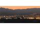 Distant elevated view of a cityscape and mountains at dusk at 1637 Wellington Springs Ave, Henderson, NV 89052