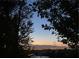 Distant city view at dusk with mountain range in background framed by trees at 1637 Wellington Springs Ave, Henderson, NV 89052