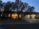 Inviting front exterior at dusk with warm lighting, mature trees, and a spacious three-car garage at 1637 Wellington Springs Ave, Henderson, NV 89052