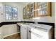 Functional laundry room with washer, dryer, sink, and ample storage cabinets at 1637 Wellington Springs Ave, Henderson, NV 89052