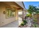 Covered patio with stone columns, lush landscaping, and outdoor grill area at 1637 Wellington Springs Ave, Henderson, NV 89052