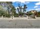 Street view of the home showcasing the lush front yard with mature trees at 1674 Palma Vista Ave, Las Vegas, NV 89169