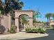 Community entrance sign, 'Monument Pointe,' framed by lush greenery and a gated entry at 1753 Tanner Cir, Henderson, NV 89012