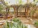Backyard wooden pergola surrounded by lush greenery, offering a peaceful seating area at 1753 Tanner Cir, Henderson, NV 89012