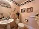 Charming powder room decorated with pink wallpaper and a pedestal sink at 1753 Tanner Cir, Henderson, NV 89012