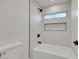 Bright, tiled bathtub with a showerhead, small window, and built-in shelving at 193 Jeri Dr, Henderson, NV 89074