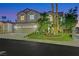 Two-story home with a three-car garage, well-manicured lawn, and mature trees at dusk at 193 Jeri Dr, Henderson, NV 89074