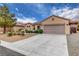 Charming single-story home has desert landscaping with a long driveway and a two car garage at 2092 Wildwood Lake Street, Henderson, NV 89052