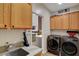 Functional laundry area equipped with sleek, modern washer and dryer units and a convenient utility sink at 2092 Wildwood Lake Street, Henderson, NV 89052