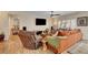 Comfortable living room featuring wood-look tile floors, an orange sofa, and natural light at 2092 Wildwood Lake Street, Henderson, NV 89052