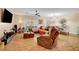 Bright living room featuring an orange sofa and a recliner with wood-look tile flooring at 2092 Wildwood Lake Street, Henderson, NV 89052
