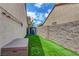 Narrow, well-maintained side yard featuring artificial turf, a storage box, and access gate to backyard of property at 2092 Wildwood Lake Street, Henderson, NV 89052