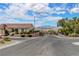 Wide street view showcases the home's curb appeal with tidy landscaping and mountain views in the distance at 2092 Wildwood Lake Street, Henderson, NV 89052