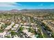Aerial view of a community with mature trees, lush greenery, and a backdrop of mountains at 2097 Eaglepath Cir, Henderson, NV 89074