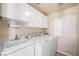 Bright laundry room with white cabinets, sink, and modern washer and dryer at 2097 Eaglepath Cir, Henderson, NV 89074