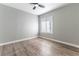 Well-lit bedroom features wood-look flooring, neutral paint, and a window with blinds at 2346 Roan Ave, Las Vegas, NV 89119