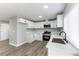 Modern kitchen featuring white cabinetry, stainless steel appliances, and wood-look floors at 2346 Roan Ave, Las Vegas, NV 89119