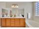 Bathroom featuring double sinks, a soaking tub, and glass block window at 2349 Orangeburg Pl, Henderson, NV 89044