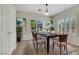 Bright dining room showcasing a wooden table and chairs, modern art, and natural light streaming through the windows at 2349 Orangeburg Pl, Henderson, NV 89044