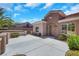 Welcoming front exterior featuring lush landscaping, stucco walls, a tile roof, and a paved driveway at 2349 Orangeburg Pl, Henderson, NV 89044