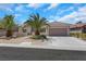 Charming single-story home featuring a two-car garage and mature landscaping with palm trees at 2349 Orangeburg Pl, Henderson, NV 89044