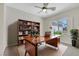 Inviting home office features a classic wooden desk, a cozy chair, a bookshelf, and natural light at 2349 Orangeburg Pl, Henderson, NV 89044