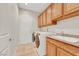 Well-lit laundry room featuring a washer, dryer, sink and wooden cabinets at 2349 Orangeburg Pl, Henderson, NV 89044