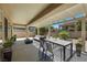 Covered patio with stylish outdoor furniture, dining area and a well-maintained landscape at 2349 Orangeburg Pl, Henderson, NV 89044